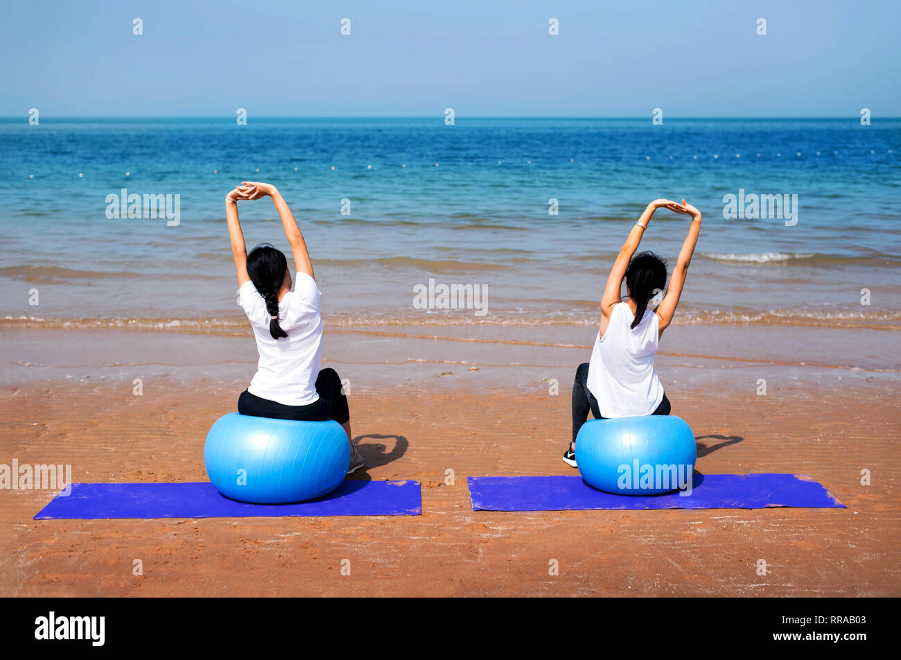Women exercising with pilates yoga ball on the beach Stock Photo