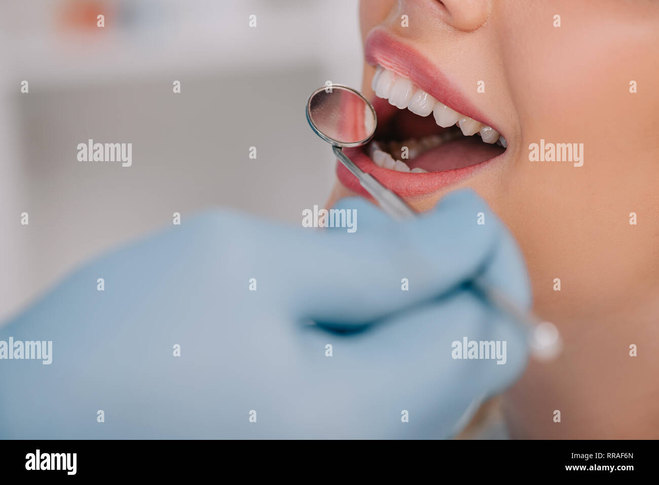 cropped view of dentist examining teeth of young woman with mouth mirror Stock Photo