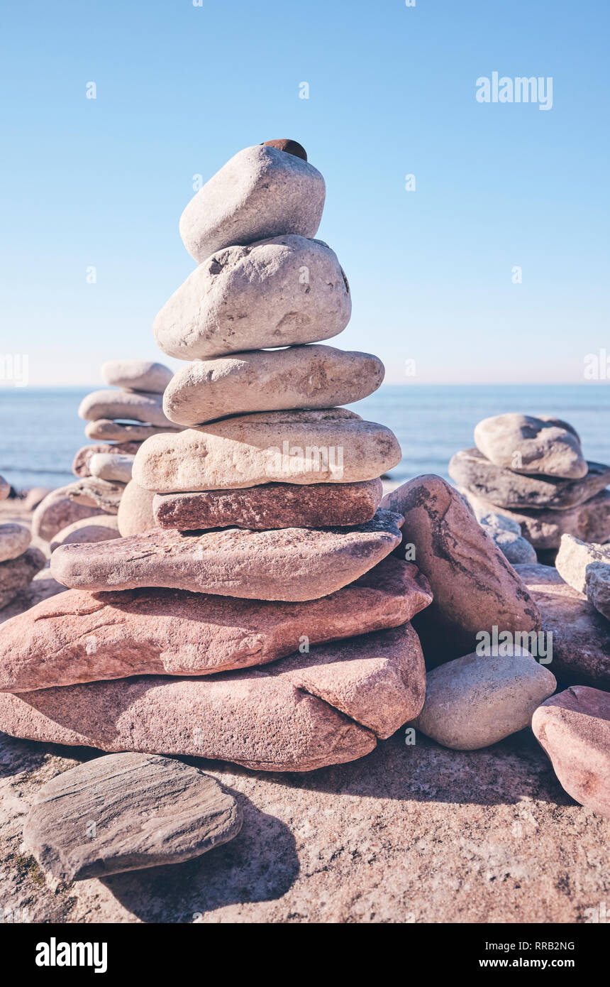Stone pyramid on a beach, balance and harmony concept, selective focus, color toning applied. Stock Photo