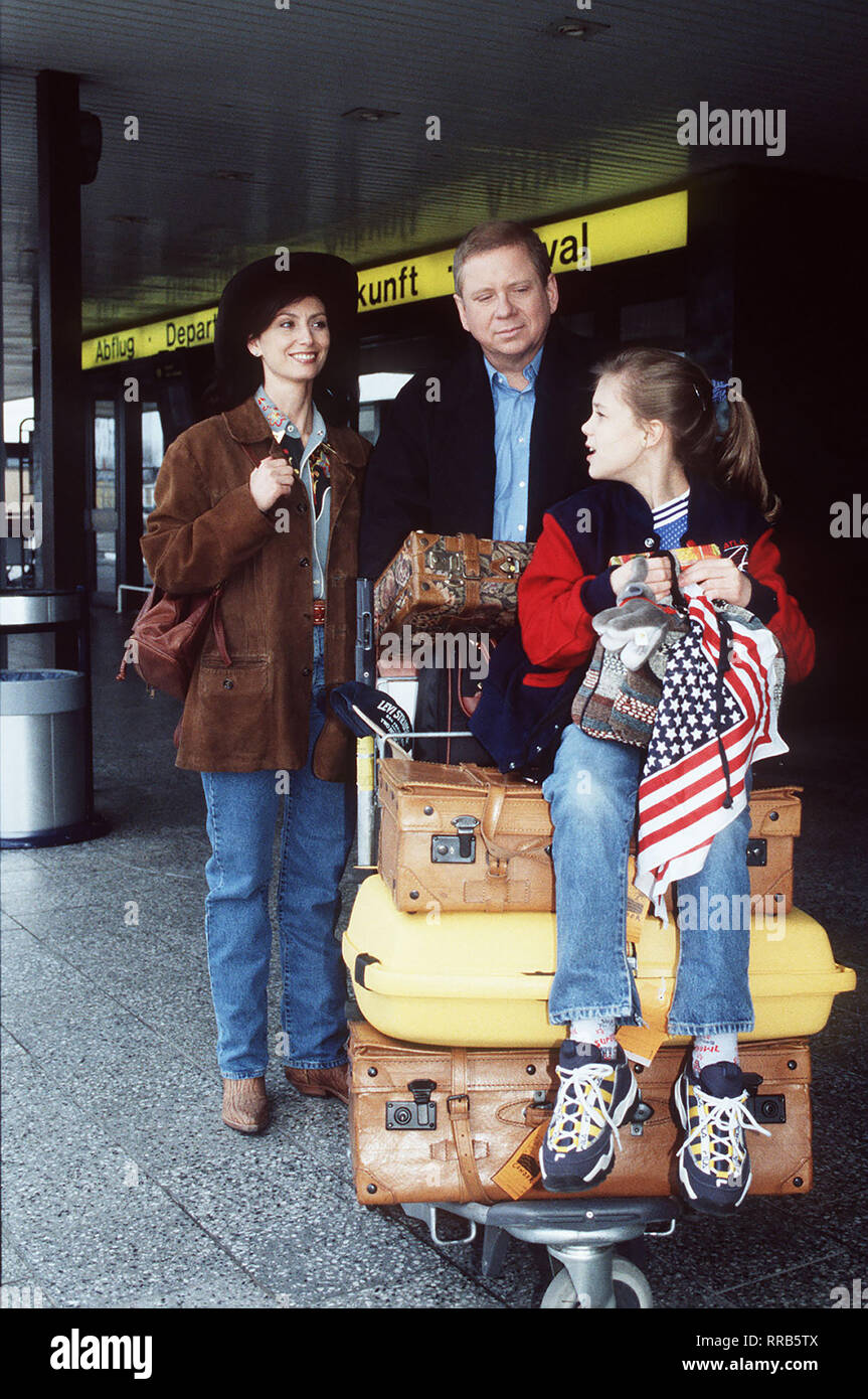 Dr. Sommerfeld (RAINER HUNOLD) ist glücklich, daß Tochter Nina (ALINA MERKAU, r) aus den Ferien in den USA zurückkehrt. Noch auf dem Flughafen stellt Nina ihm ihre Reisebekannschaft vor: Katja Franke (MARIJAM AGISCHEWA) Regie: Kai Borsche aka. Kalte Liebe - heiße Liebe 129 / Überschrift: DR. SOMMERFELD - NEUES VOM BÜLOWBOGEN / BRD 1996/7 Stock Photo