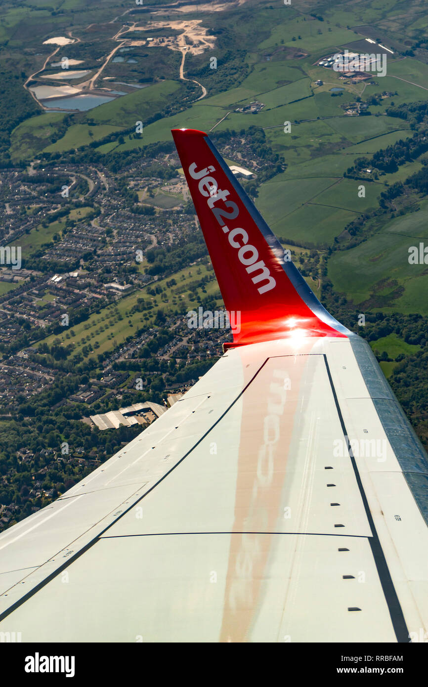 Wing of a Boeing 737 flying over the British countryside, Scotland. Stock Photo