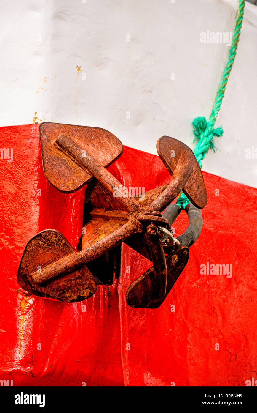 rusty anchor on red and white ship Stock Photo