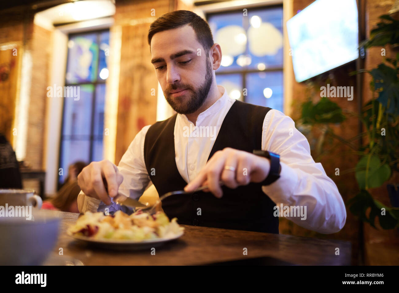 Handsome Businessman Eating in Restaurant Stock Photo