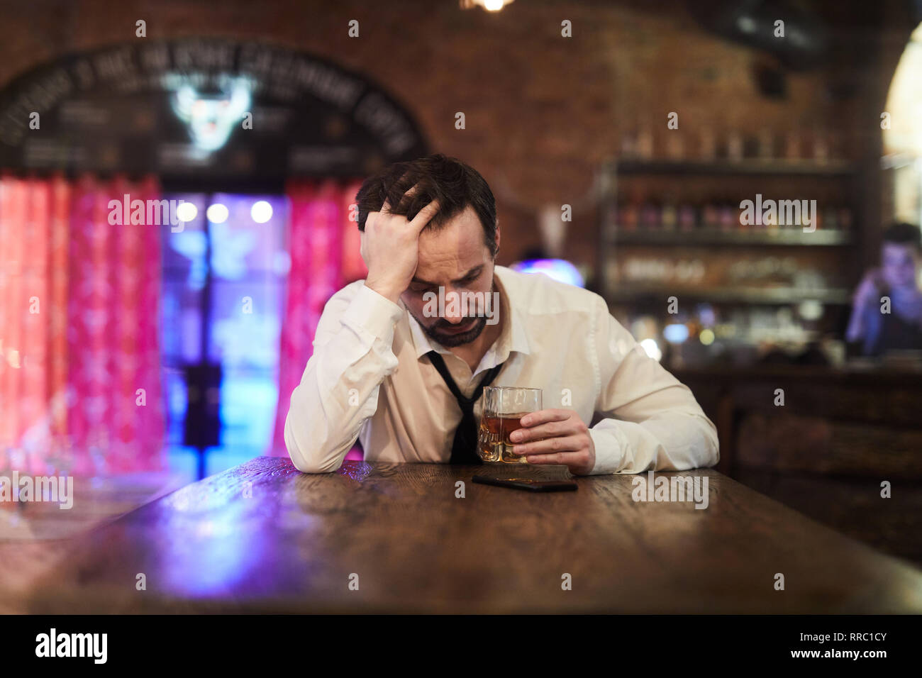 Depressed Man Drinking in Bar Stock Photo