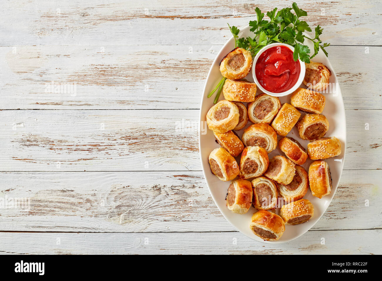 Delicious homemade sausage rolls on a white oval platter with tomato sauce  on a wooden rustic table, finger food, english cuisine, view from above, fl  Stock Photo - Alamy