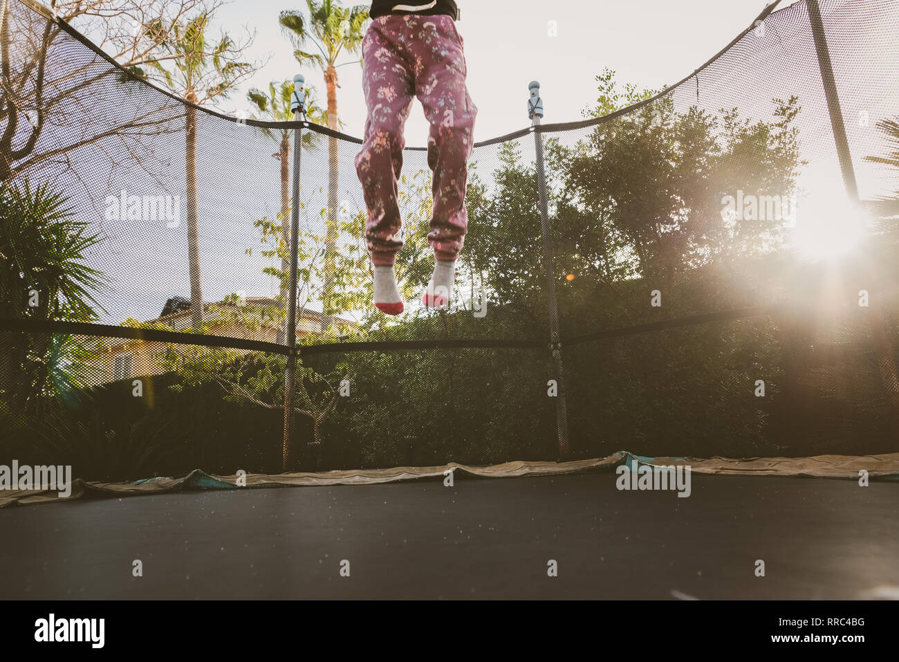 Little girl enjoying her vacation jumping on the trampoline doing