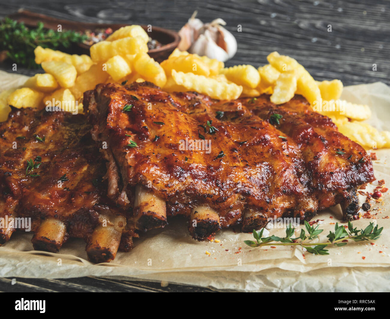 grilled pork ribs with sauce on a cutting board, french fries Stock Photo