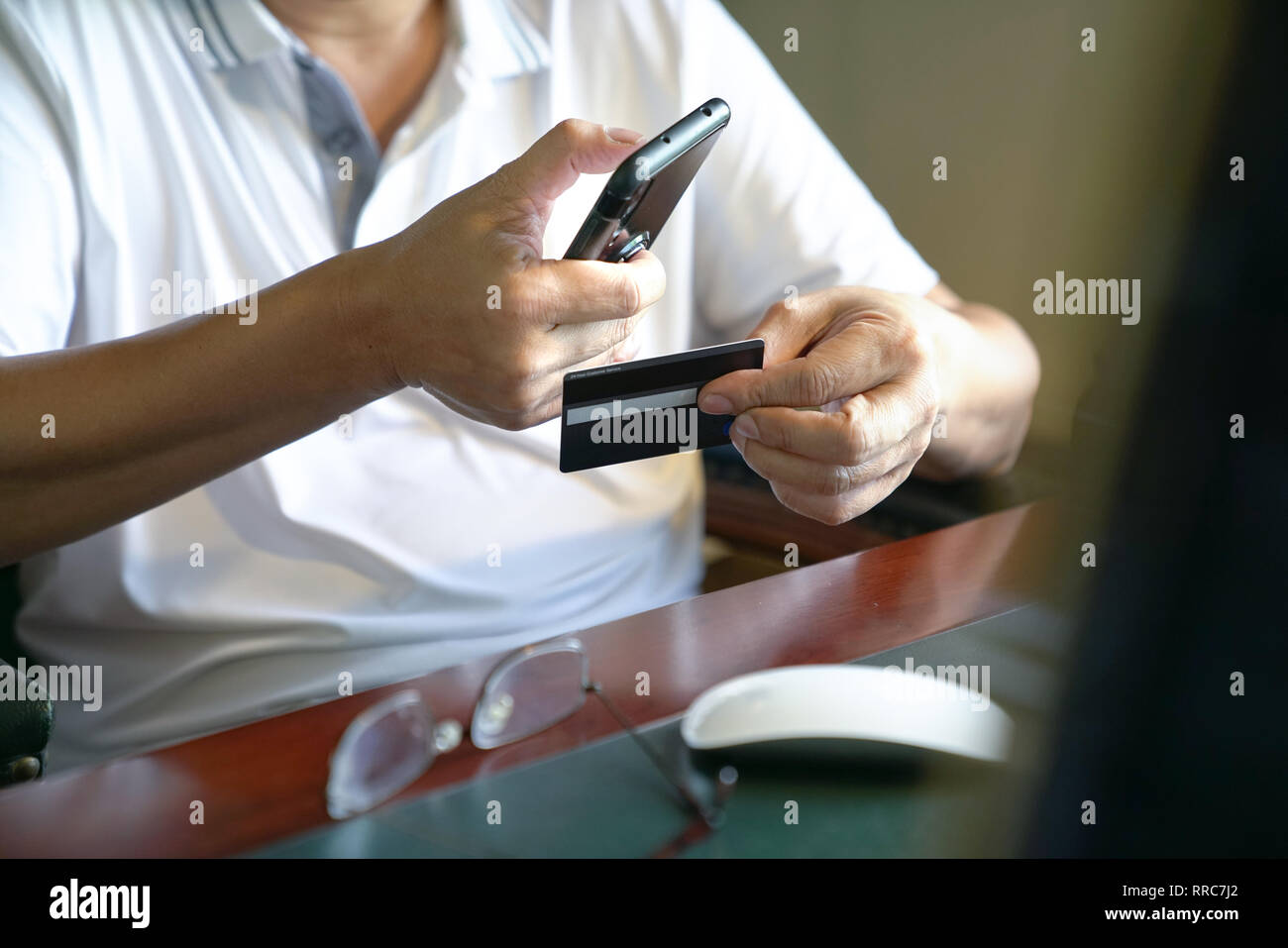 Online payment or ecommerce concept : man holding a mobile phone and credit card for online shopping Stock Photo