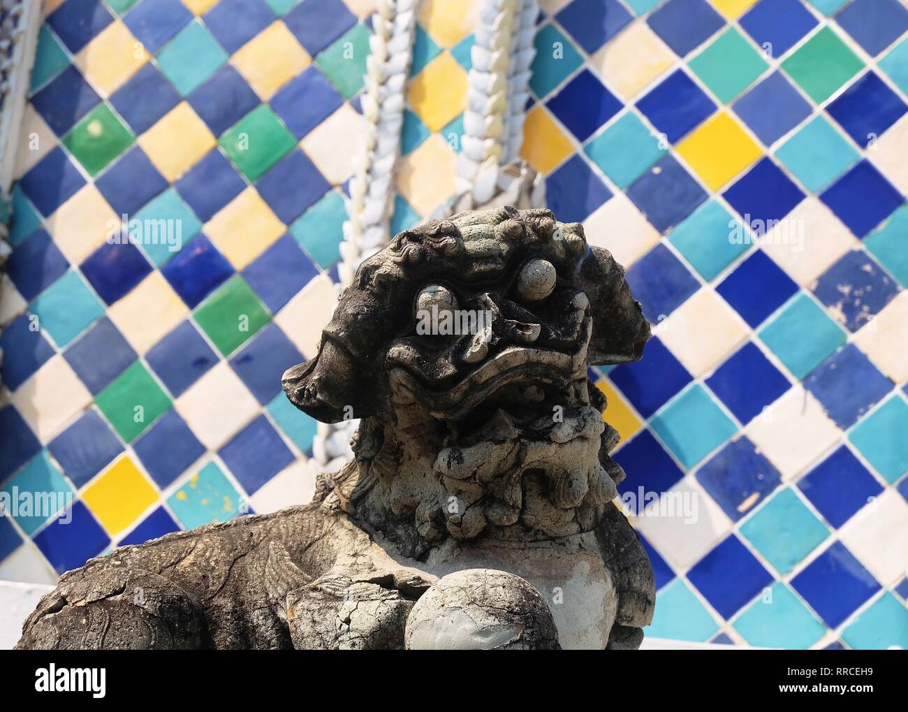 Ancient Chinese Lion Sculpture or Guardian Lion Holding A Ball in Right Foot at The Entrance or The Inner Shrine, Symbol of Protection and Power in Or Stock Photo