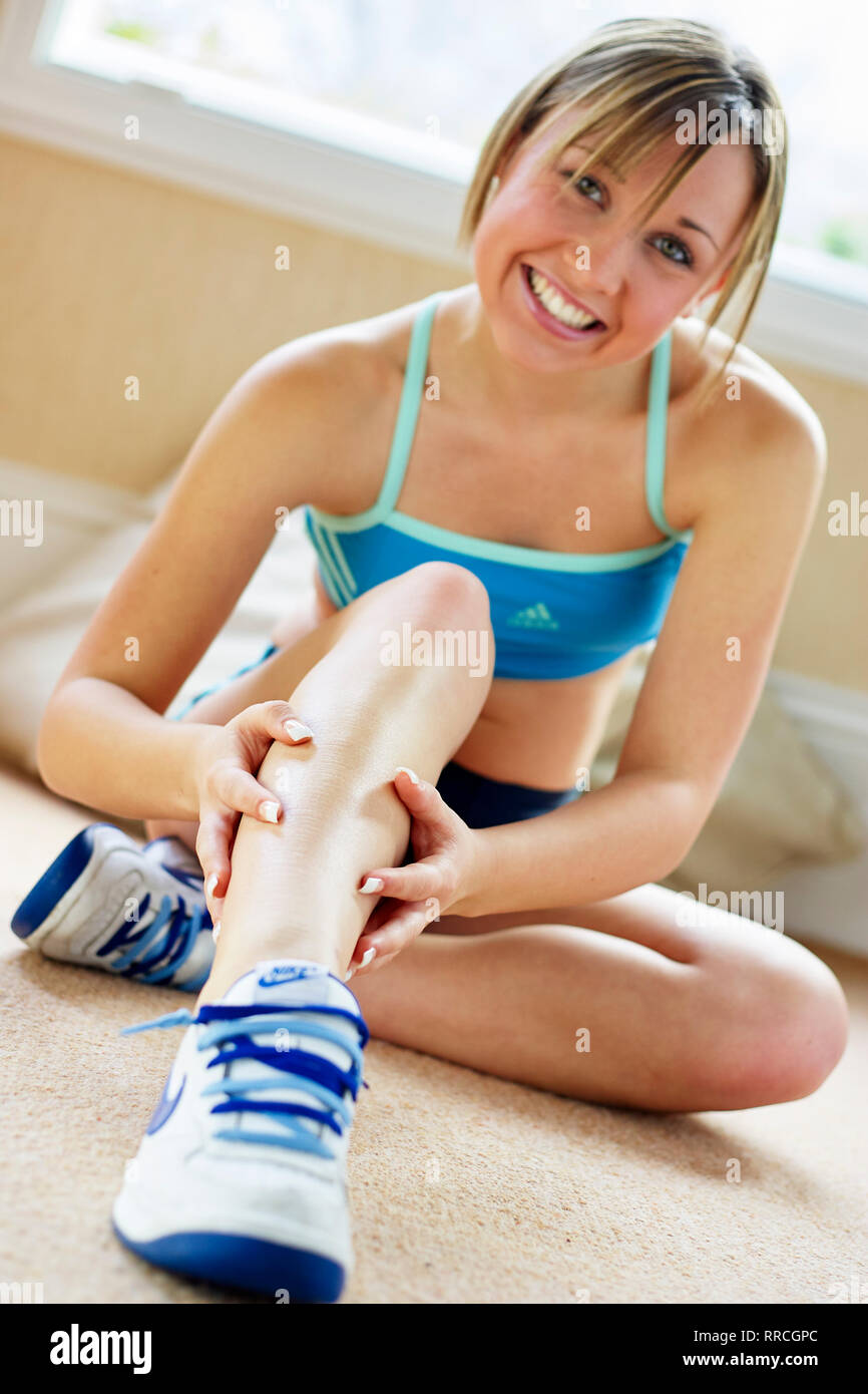 Teen girl sat stretching on the floor Stock Photo