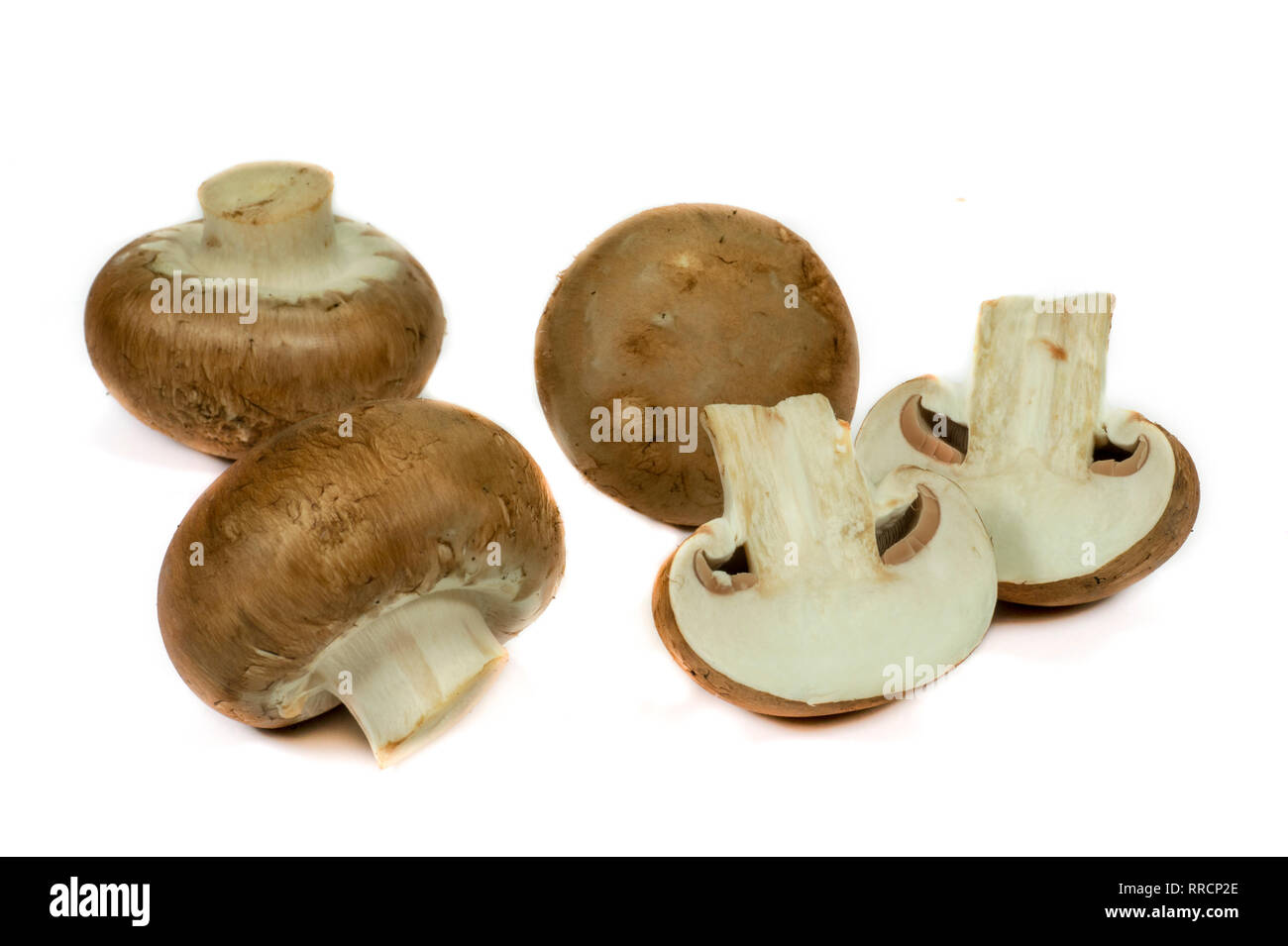 Fresh whole and halved brown (Baby Bella) mushrooms isolated on a white