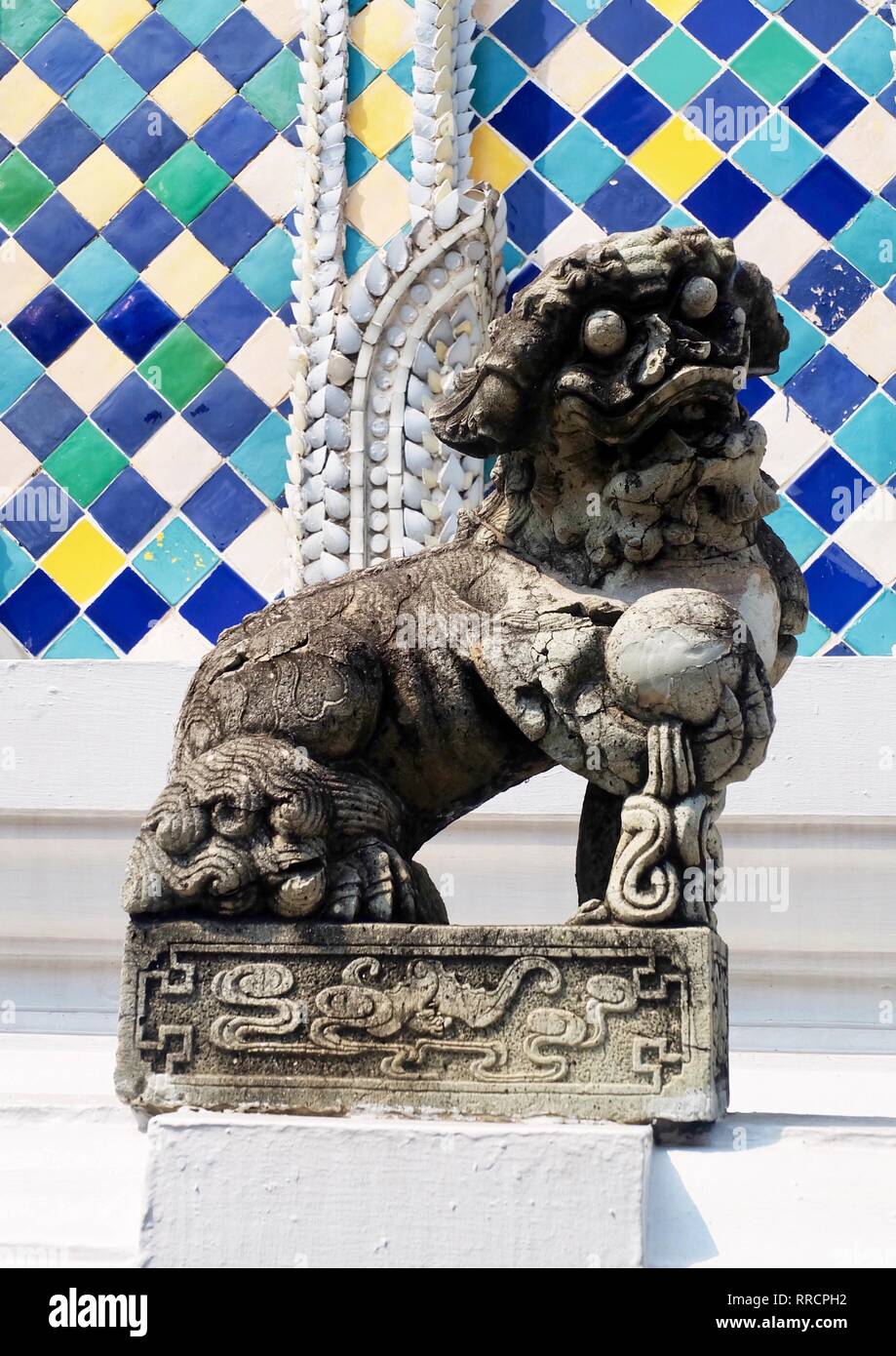 Ancient Chinese Lion Sculpture or Guardian Lion Holding A Ball in Right Foot at The Entrance or The Inner Shrine, Symbol of Protection and Power in Or Stock Photo