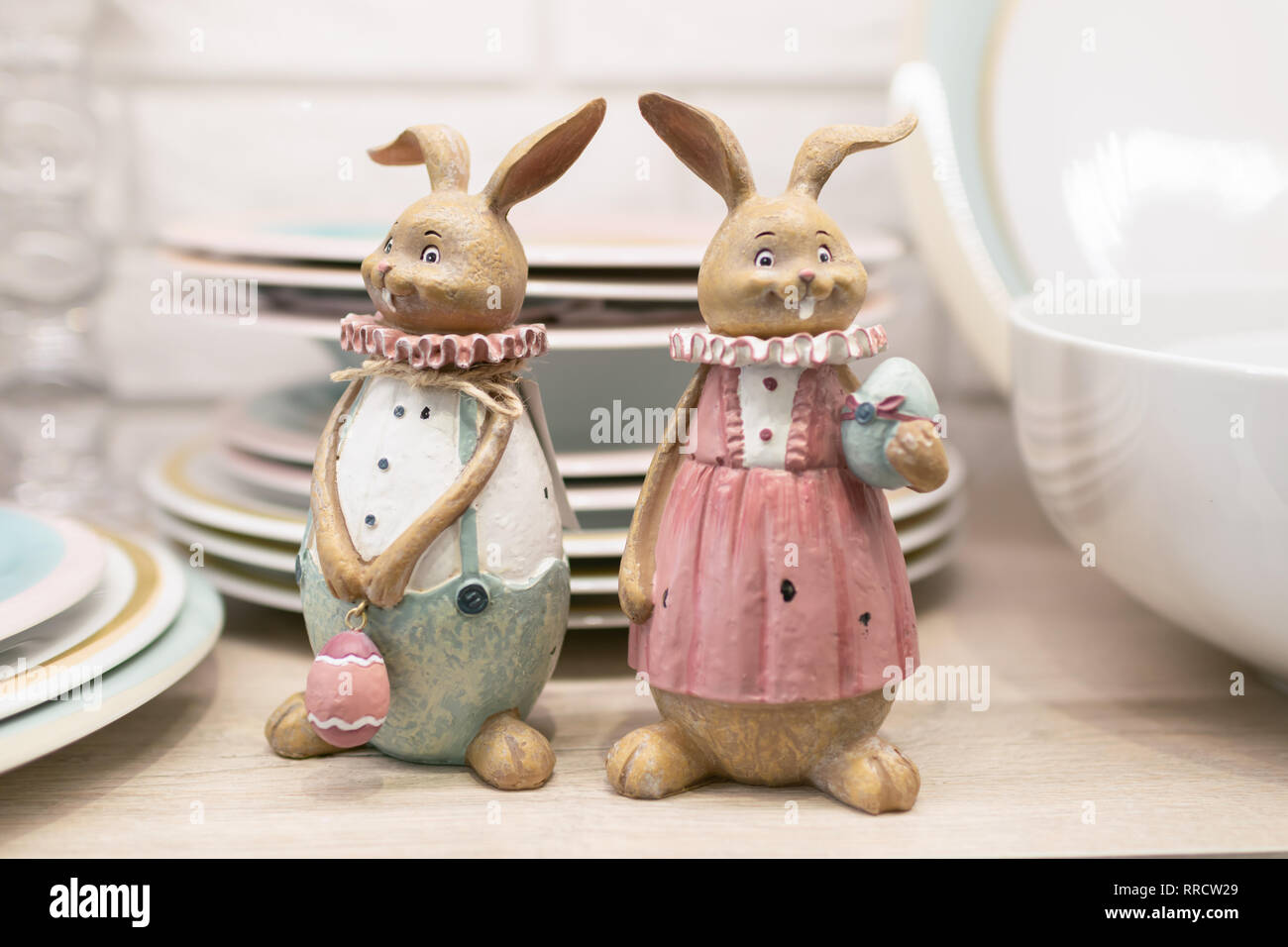 Two Easter pottery hare on a kitchen table shelf. Ceramic figurines for serving the festive table. Selective focus Stock Photo