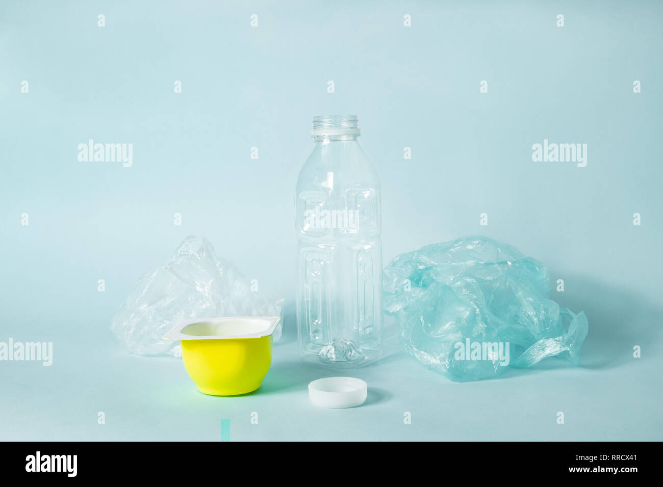 Disposable plastic items of every day use on blue background. Concept