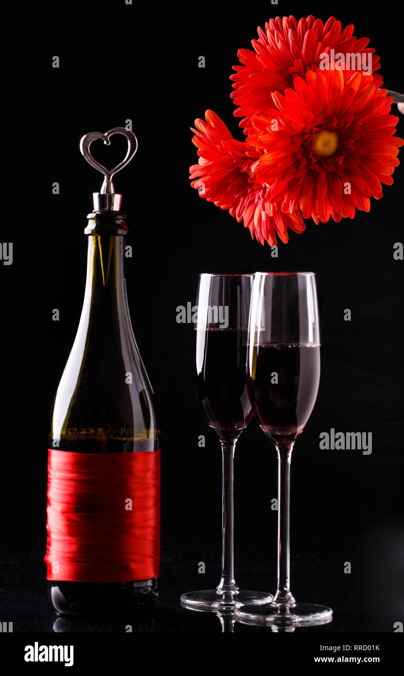Flowers, bottle on black background Stock Photo