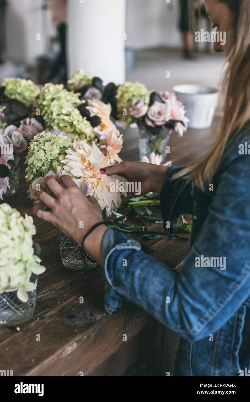 Happy Lady Near Wooden Table With Bunches Of Fresh Chrysanthemums