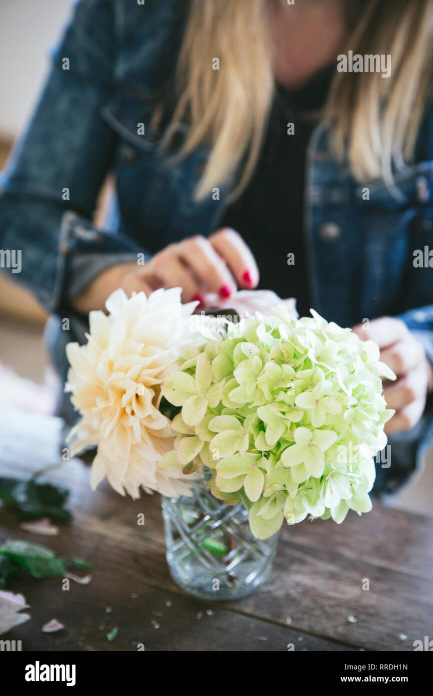 Happy Lady Near Wooden Table With Bunches Of Fresh Chrysanthemums