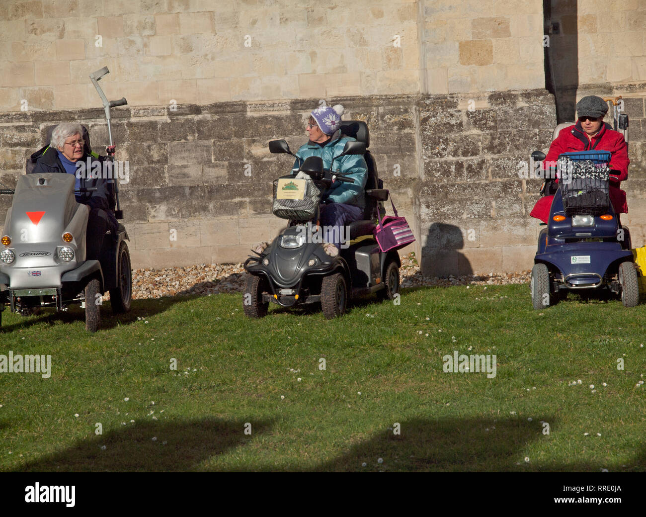Three women sit in their mobility scooters in a sunny Chichester Stock