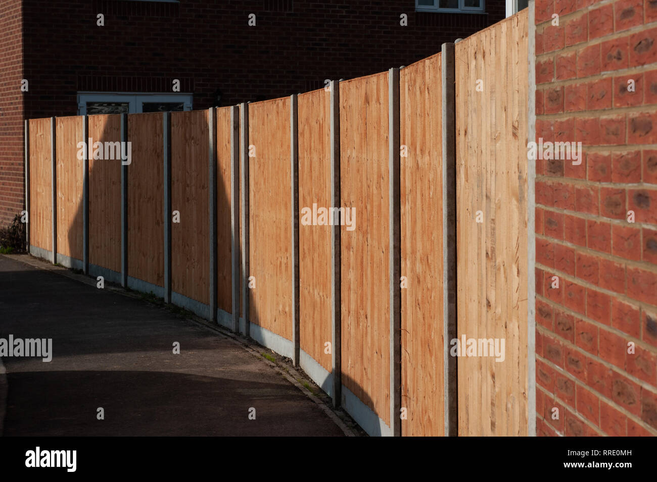 Brand new garden fencing on concrete base with concrete posts on housing estate. Stock Photo