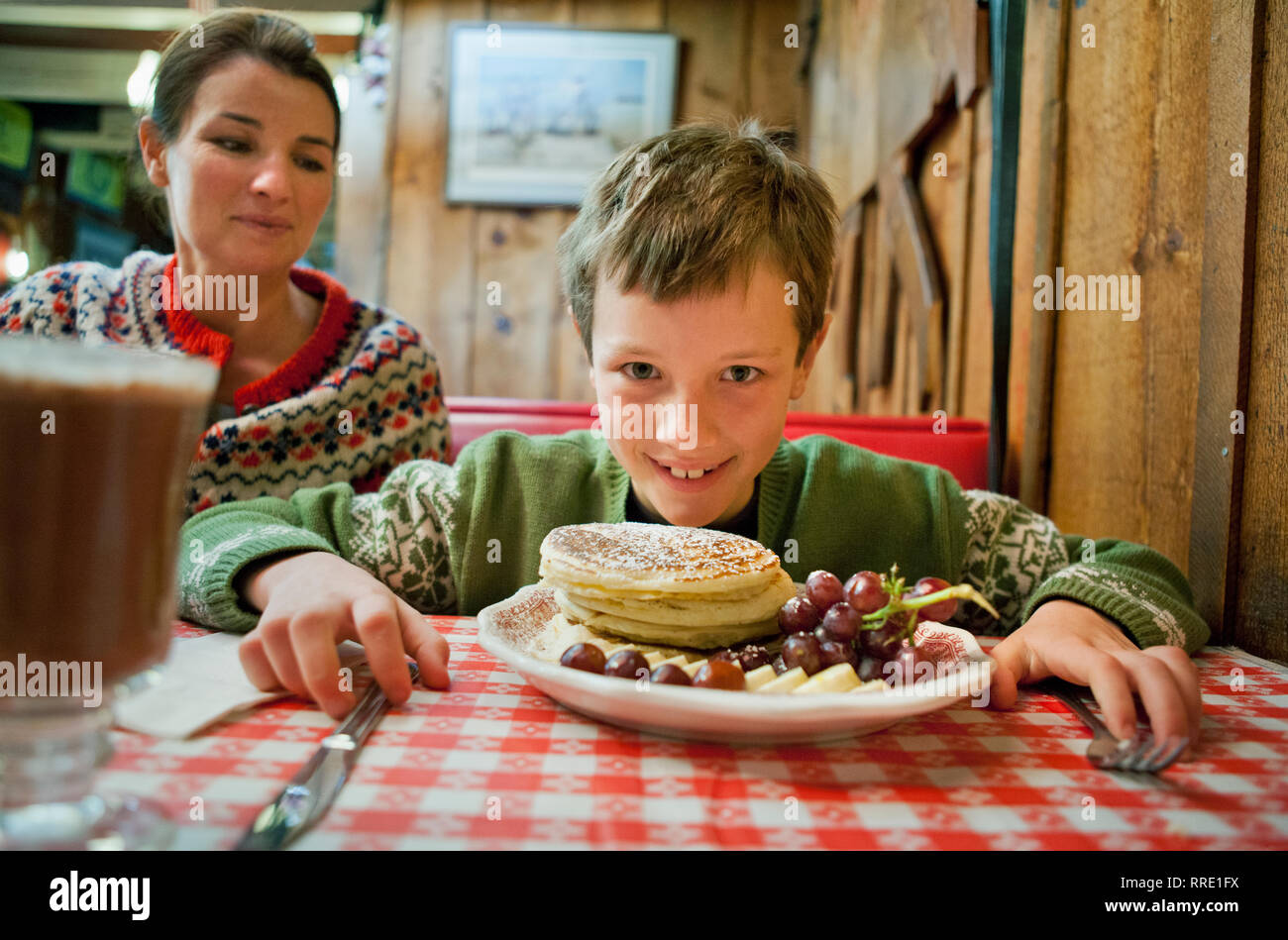 Portrait of a young boy eating breakfast at a diner. Stock Photo