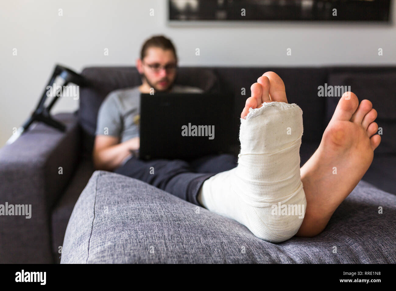 man with a broken leg is surfing the internet Stock Photo