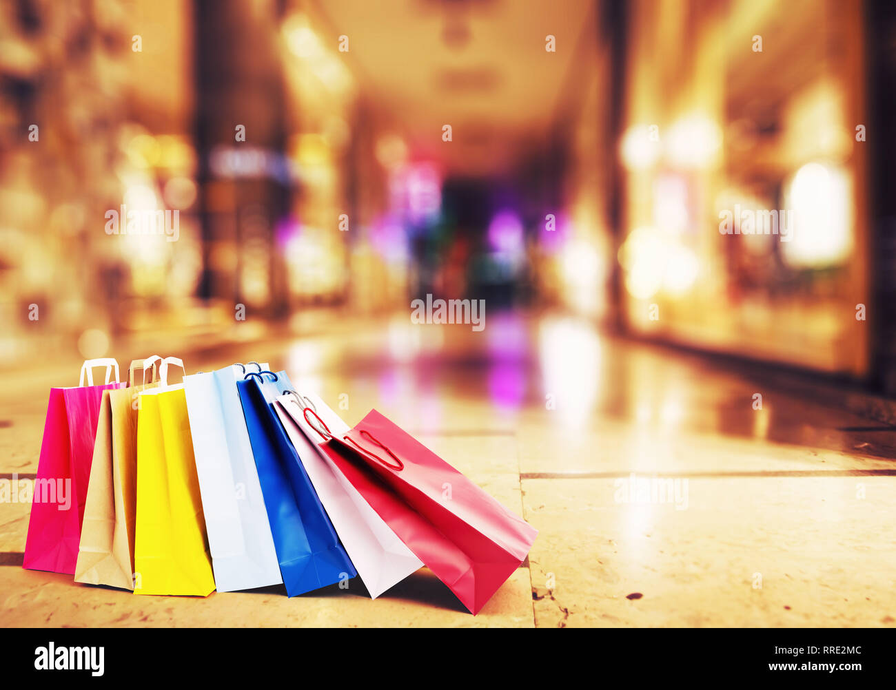 Colorful shopping bags on the ground with a gallery of luxurious shops in the background Stock Photo