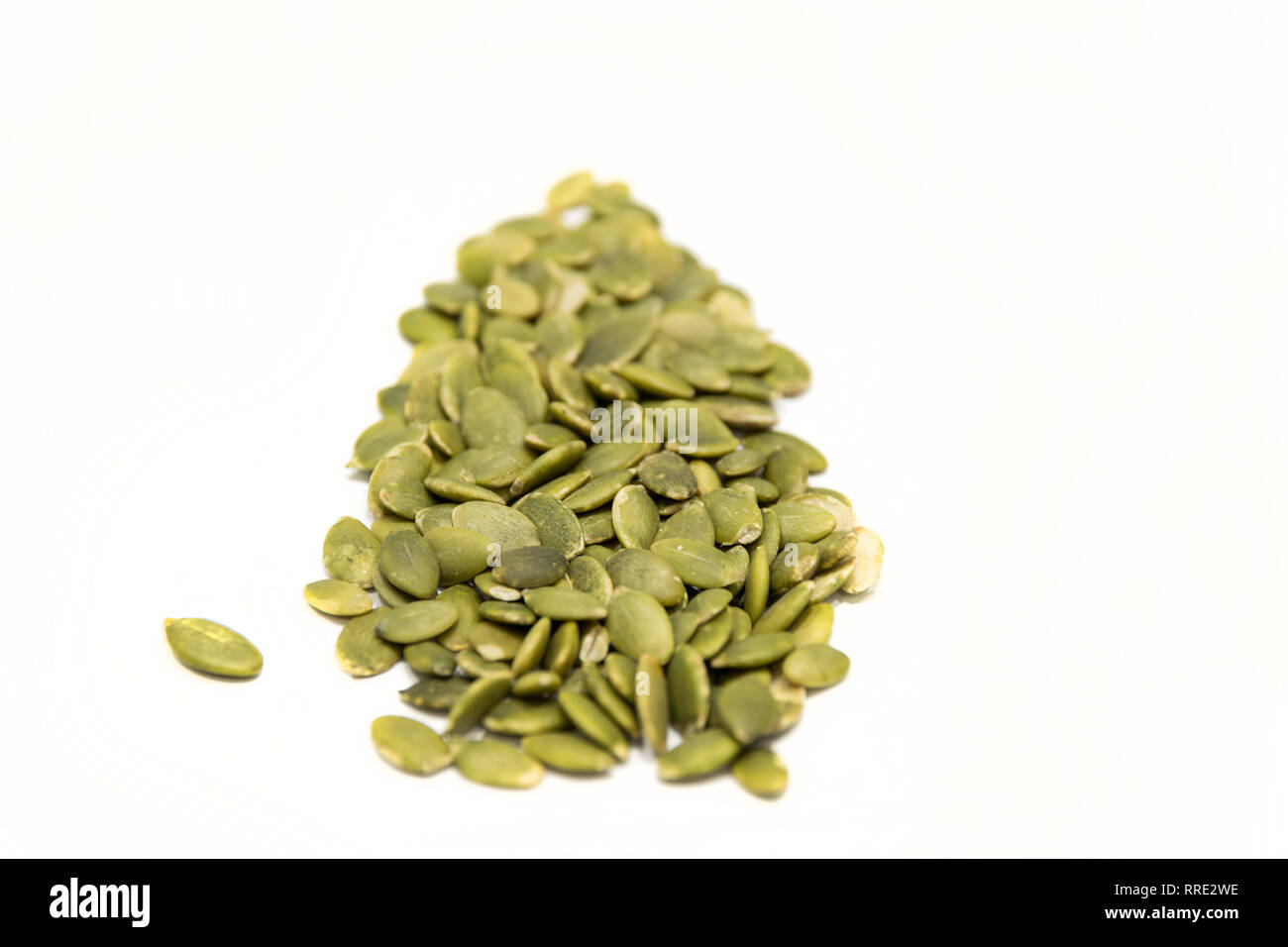 Leaf shape made with green pumpkin seed isolated on white background. Vegan green leaf food concept Stock Photo