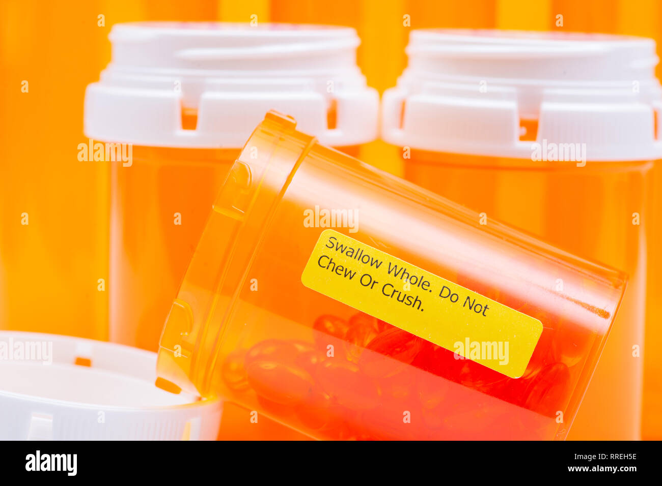 Docusate sodium soft gel capsules in orange container with SWALLOW WHOLE DO NOT CHEW OR CRUSH LABEL. Stock Photo