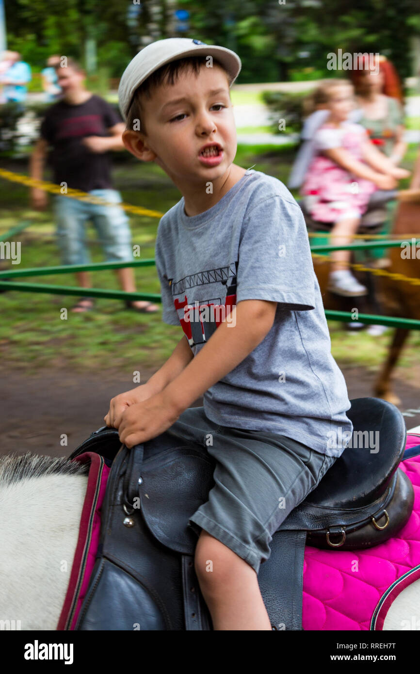Tunder Fesztival (Fairies' Festival) in Sopron, Hungary on 9 June 2018 - boy child riding a pony horse looking away Stock Photo