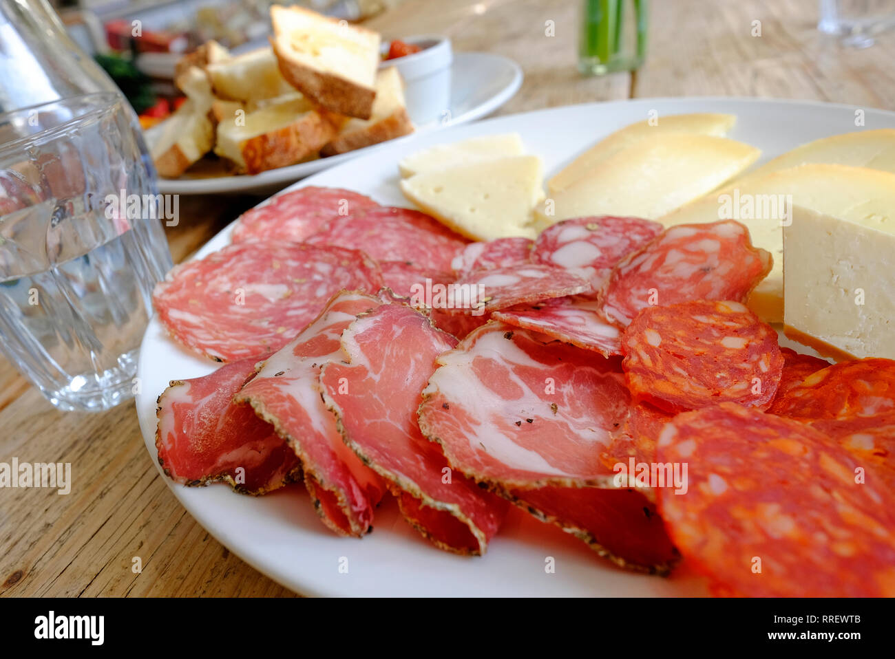 selection of italian hams and cheeses on white plate Stock Photo