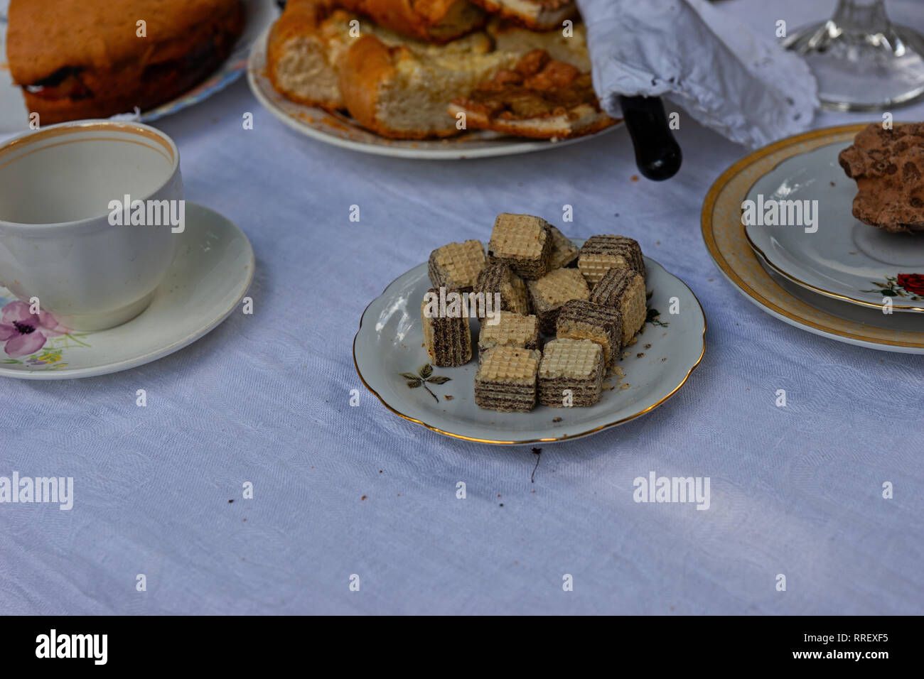 Details of a tea table. Tea service, utensils, plates, and vases filled