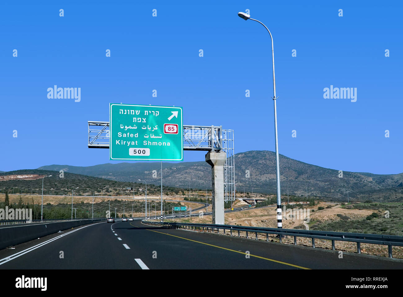 modern highway in Israel with trilingual Hebrew, Arabic, English direction sign Stock Photo