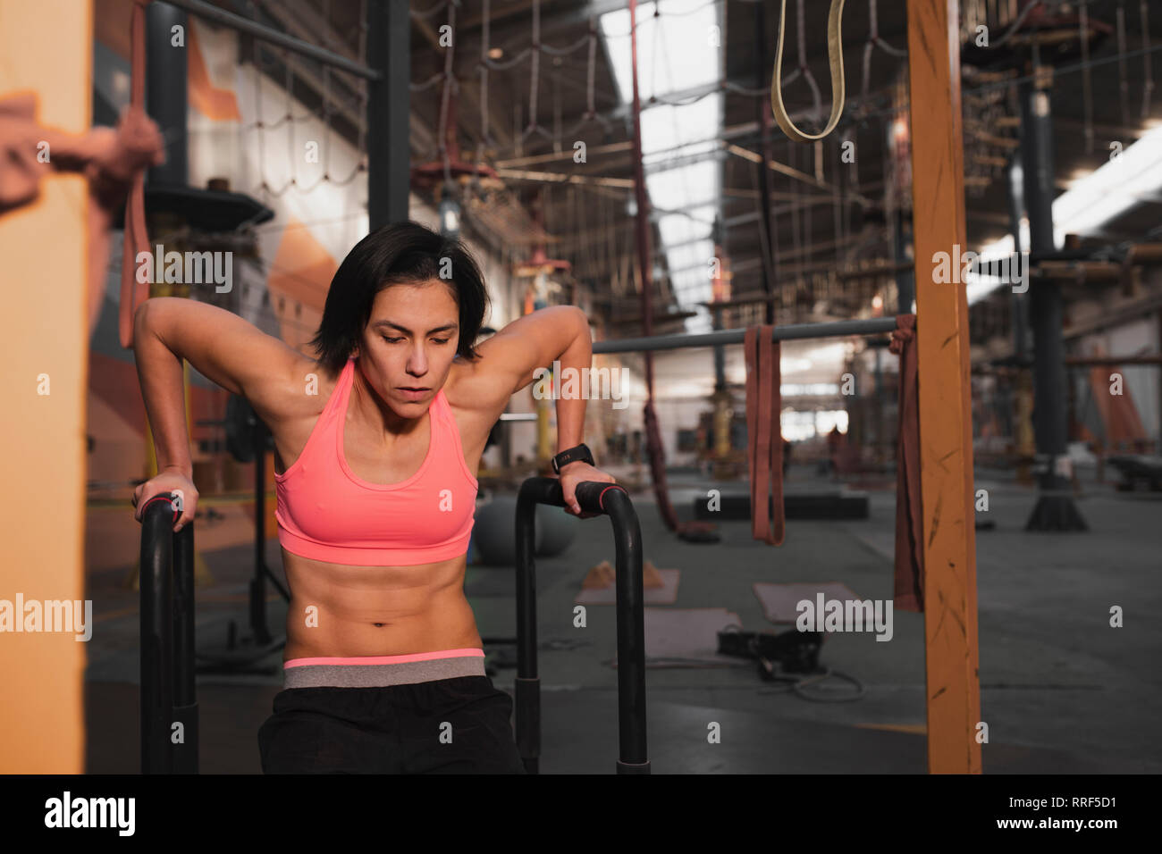 Young slim sportive lady in sportswear doing pull up exercises on ...