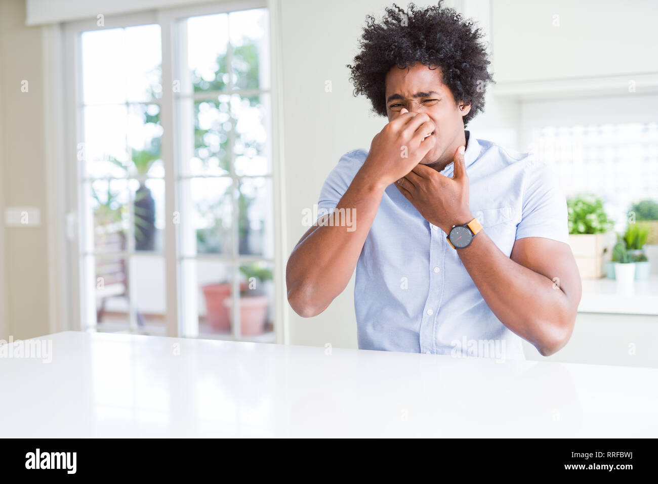 African American business man smelling something stinky and disgusting