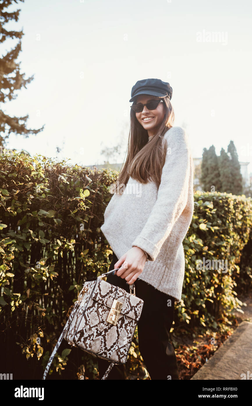 Beautiful young woman posing in the park near the hedge Stock Photo - Alamy