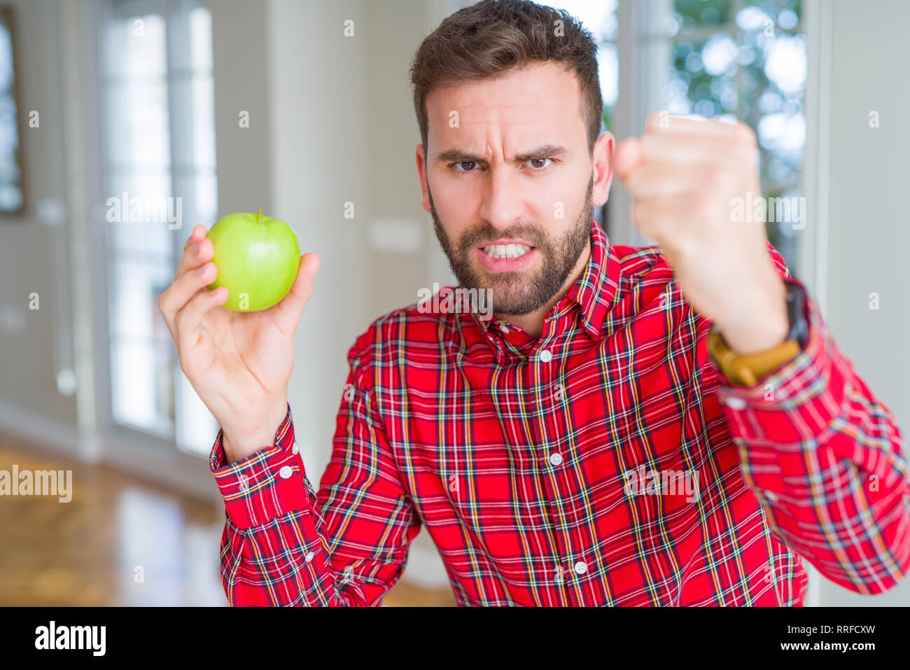 Handsome Man Eating Fresh Healthy Green Apple Annoyed And Frustrated Shouting With Anger Crazy 