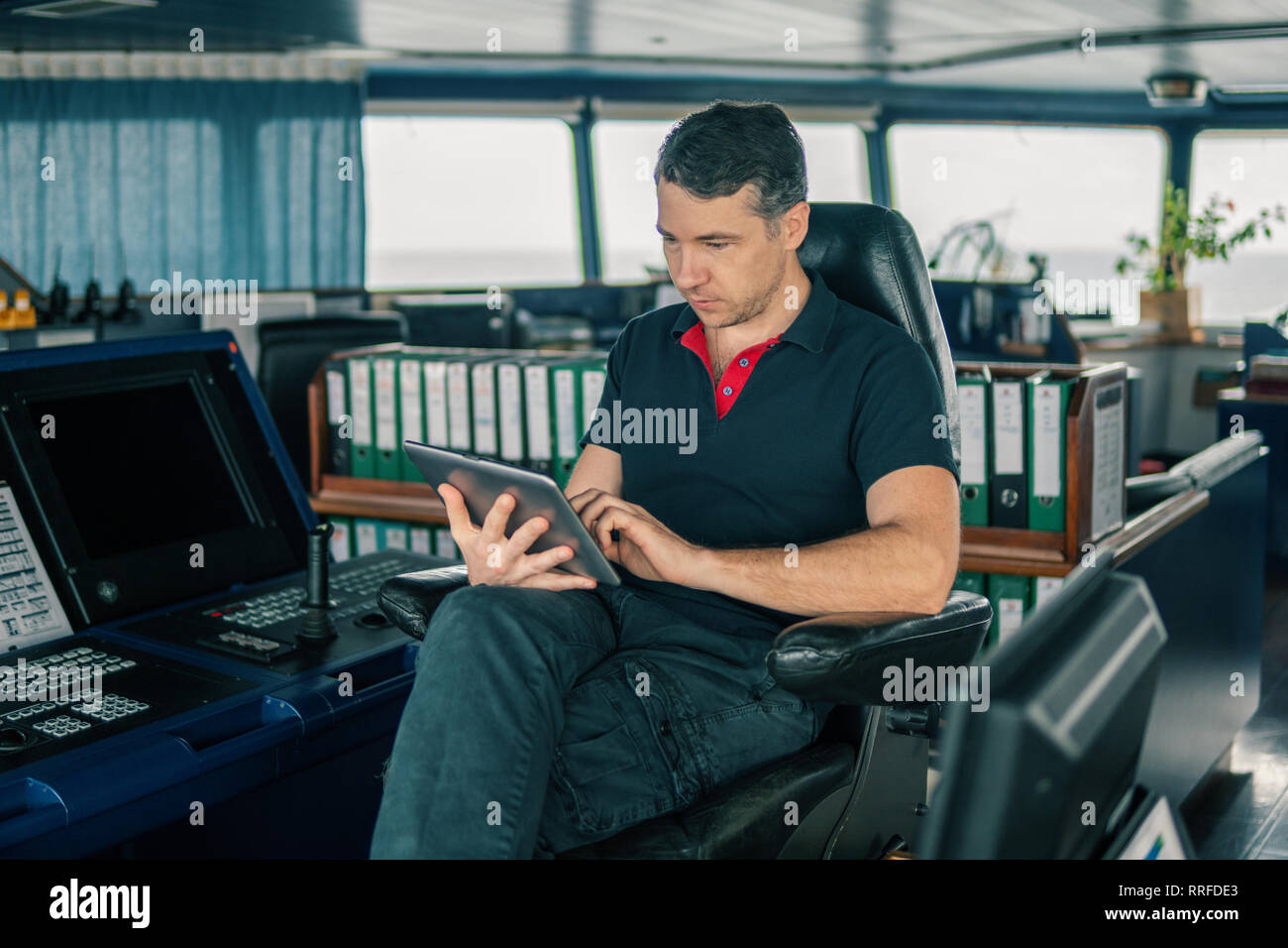 chief officer on navigation bridge watching digital tablet Stock Photo ...