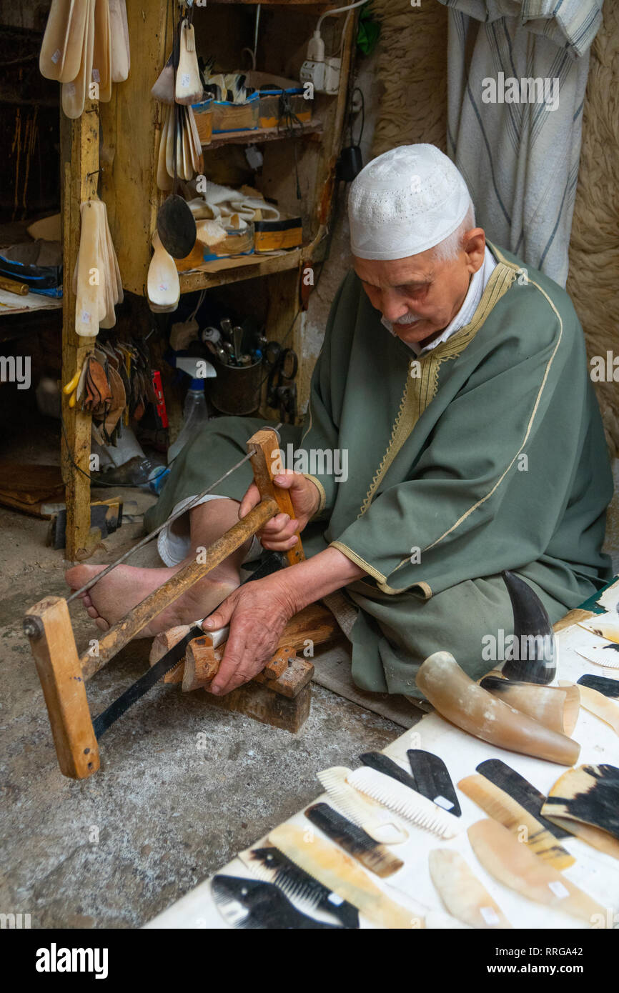 Man saws horn to make combs in an alleyway in the Old City (Medina) of Fez, UNESCO World Heritage Site, Morocco, North Africa, Africa Stock Photo