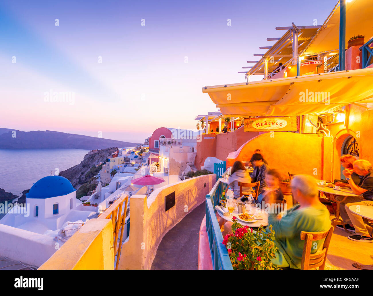 View of restaurant in Oia village overlooking the sea at dusk, Santorini, Cyclades, Aegean Islands, Greek Islands, Greece, Europe Stock Photo