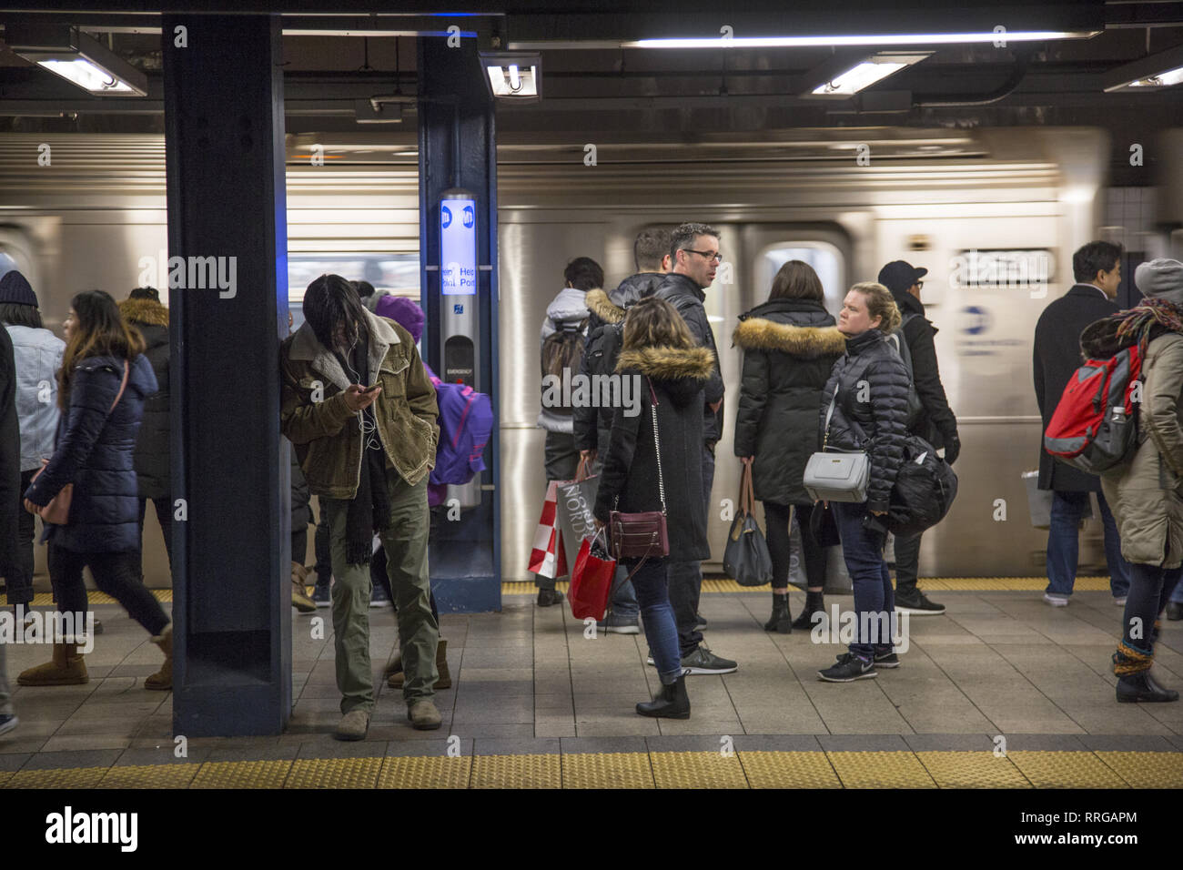 Subway riders wait on the platform for a train at the Broadway
