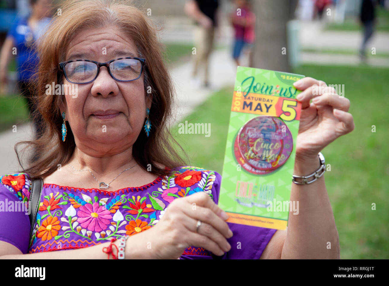 Hispanic woman selling annual button to support the Cinco de Mayo Parade and festivities. St Paul Minnesota MN USA Stock Photo