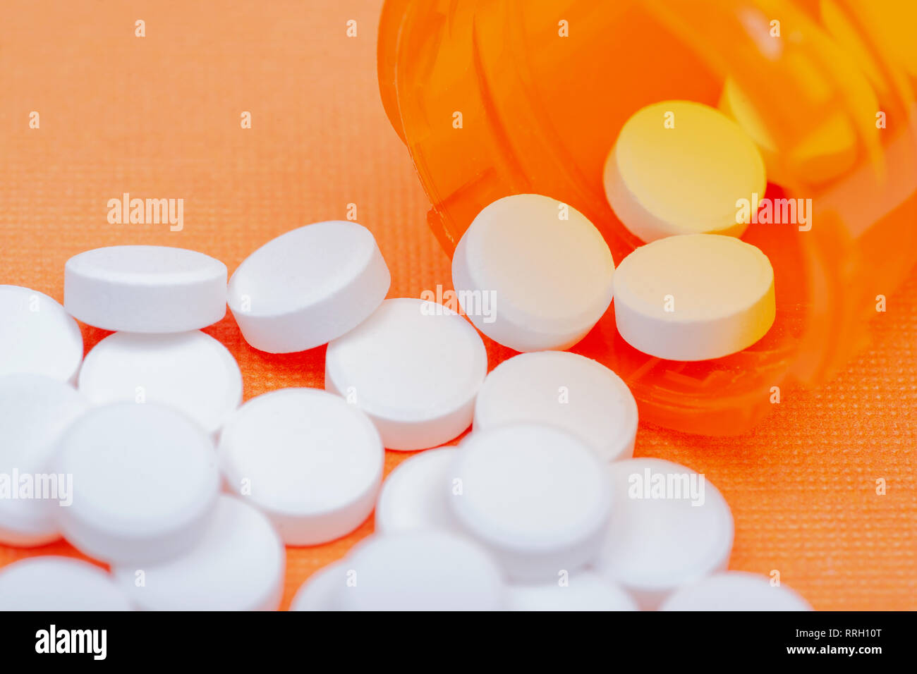 Nonsteroidal antiinflammatory drugs. Acetaminophen white tablets on orange background Stock