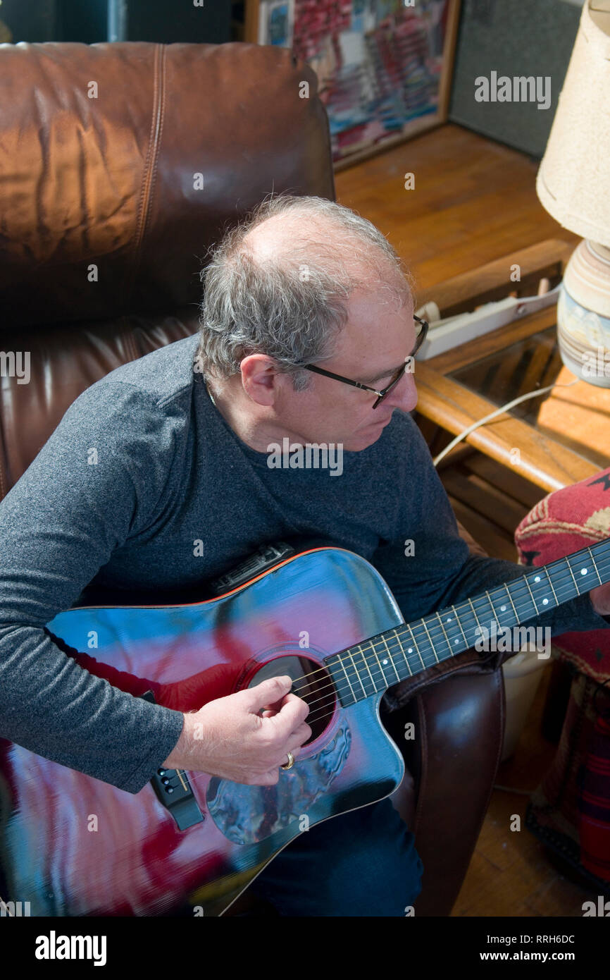 middle age senior man musician playing acoustic guitar happy and smiling Stock Photo