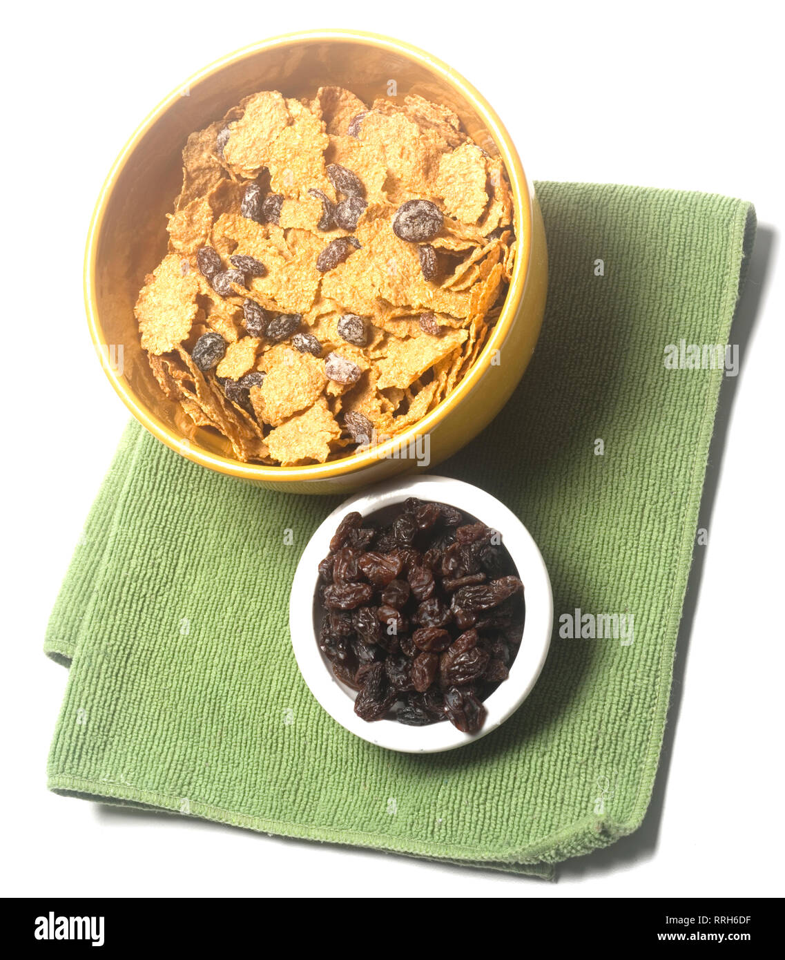 breakfast cereal bowl of raisin bran with bowl of raisins isolated on white Stock Photo