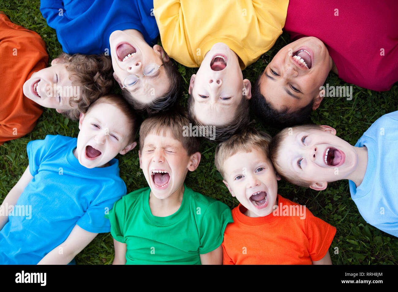 Group of Boys Yelling in Grass Outside Stock Photo