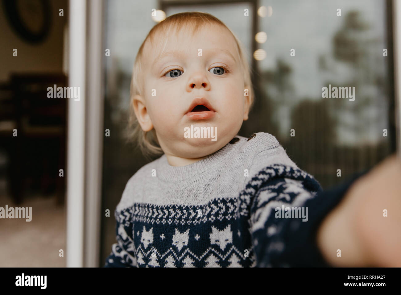 Cute Adorable Little Blonde Toddler Kid Laughing, Having Fun, and Making Silly Faces Outside at Home on the Patio Screened  Porch Stock Photo