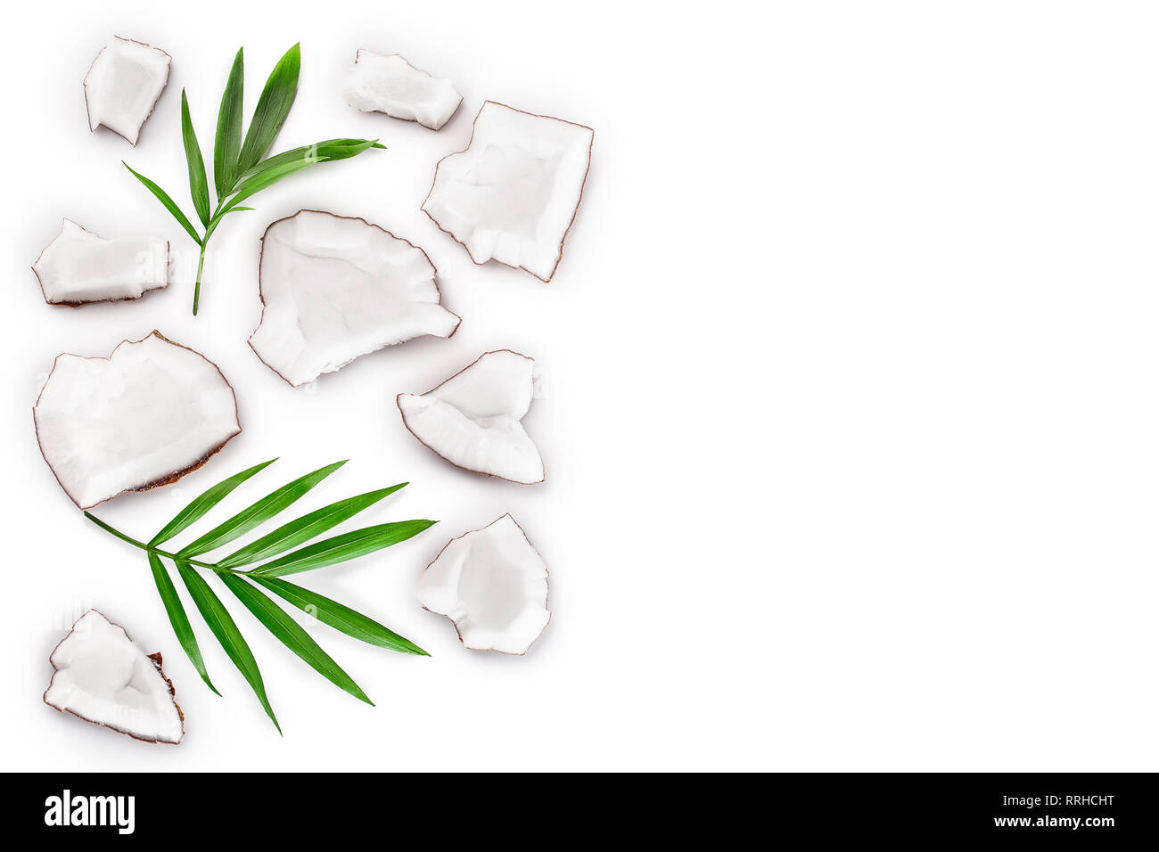 piece of coconut with leaves isolated on white background with copy space for your text. Top view. Flat lay Stock Photo