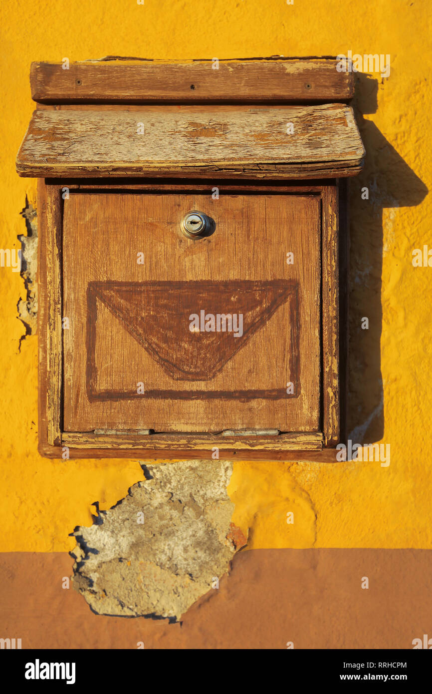 Old wooden letterbox on a yellow wall of a spanish home Stock Photo - Alamy