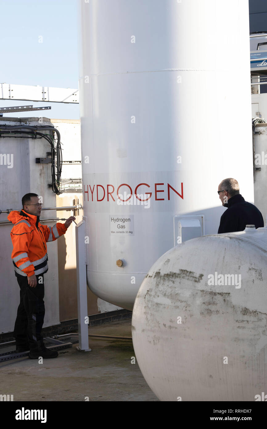 Two men next to hydrogen gas storage tank Stock Photo
