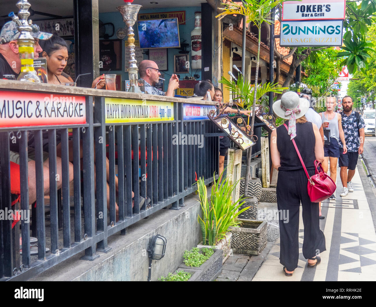 Australian tourists walking past the Joker's Bar & Grill on Jl Raya Legian, Kuta Bali Indonesia. Stock Photo